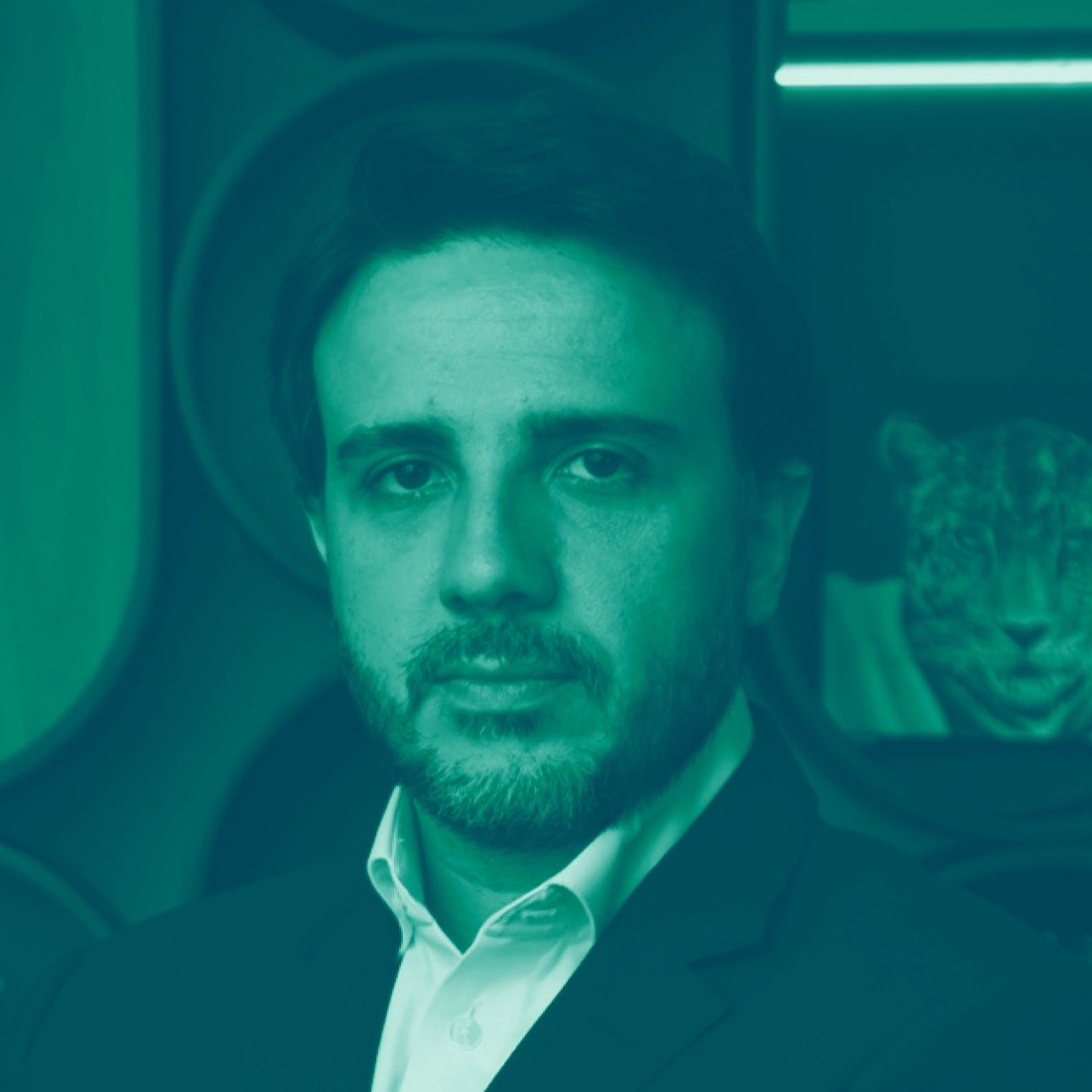 Renan Santos, founder of Missão, with the onça pintada emblem behind him