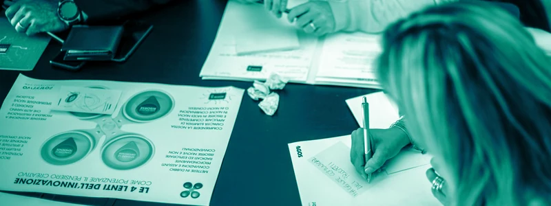 A sprint team working through research notes and sticky notes around a table